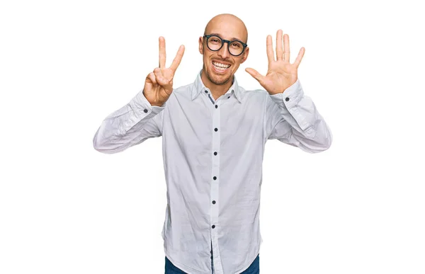 秃头的男人 留着胡子 身穿商务衬衫 戴着眼镜 用七号手指指着别人 面带微笑 自信而快乐 — 图库照片