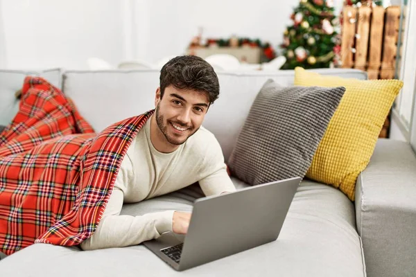 Молодий Іспаномовний Чоловік Усміхається Щасливий Лежить Дивані Використовуючи Ноутбук Вдома — стокове фото