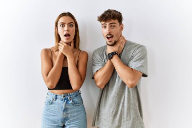 Genç ve güzel bir çift, izole edilmiş arka planda yan yana durup boğularak ölmek için bağırıyorlar. Sağlık problemi. Boğulma ve intihar konsepti. 