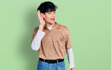 90 'ların retro tarzı giyinmiş yakışıklı hippi genç adam. Kulağı kulağında gülümsüyor ve dedikodu ya da dedikoduları dinliyor. Sağırlık kavramı. 