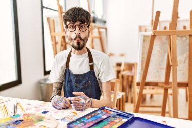 Sanat stüdyosunda sakallı İspanyol bir adam dudaklarıyla balık suratı yapıyor, çılgınca ve komik bir jest. Komik ifade. 