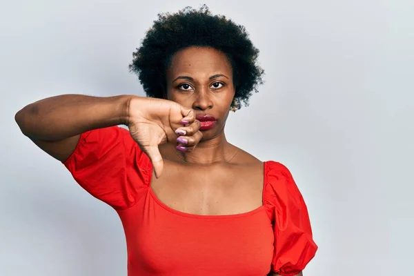 カジュアルな服を着ている若いアフリカ系アメリカ人女性は 親指を下にジェスチャーで拒絶と否定を示す不満と怒りを見ている 悪い表現 — ストック写真