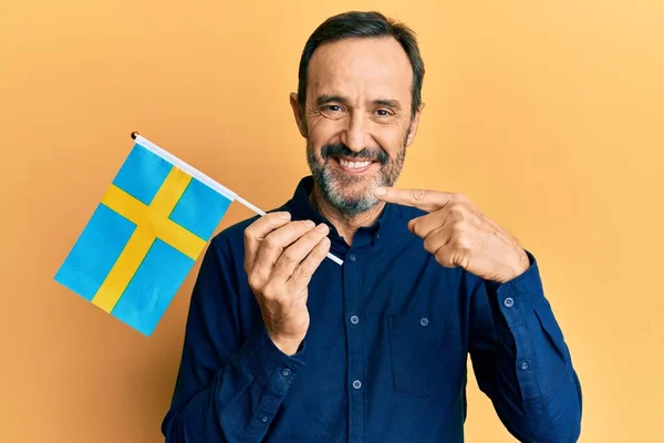 Středověký Hispánec Muž Drží Švédskou Vlajku Úsměvem Šťastný Ukazující Rukou — Stock fotografie
