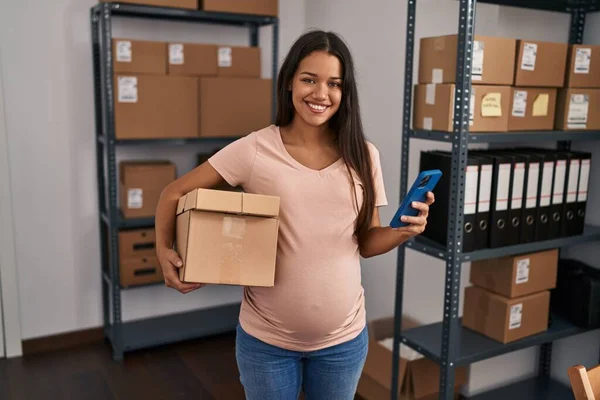 Young Latin Woman Pregnant Business Worker Using Smartphone Holding Package — Stock Photo, Image