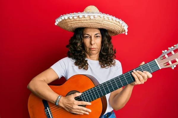 中年时 他的惊慌失措的女人拿着墨西哥帽弹奏古典吉他手的怀疑和紧张 皱着眉头因问题而烦恼 消极的人 — 图库照片