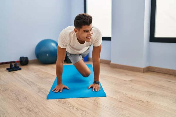 Joven Hispano Sonriendo Confiado Entrenamiento Abs Ejercicio Centro Deportivo —  Fotos de Stock