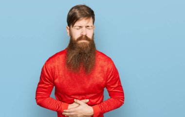 Kızıl saçlı, uzun sakallı, günlük kıyafetler giyen, elleri karnında olan bir adam. Çünkü hazımsızlık, acı verici bir hastalık, kendini iyi hissetmiyor. Ağrı kavramı. 