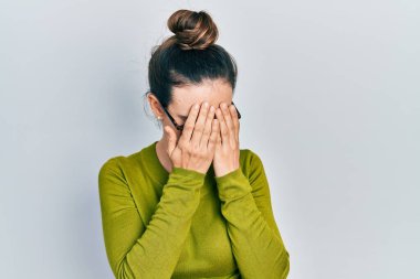 Gündelik kıyafetler giyen ve ağlarken yüzünü ellerle kapatan üzgün yüzlü gözlüklü genç İspanyol kız. depresyon kavramı. 