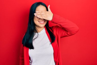 Güzel İspanyol bir kadın, burun piercingli, sıradan bakışlar takan, gülümseyen ve gülümseyen bir gözlük takan, elleri yüzünde, şaşırtmak için gözleri kapatan. kör kavram. 