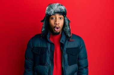 Sakallı, kışlık şapkalı ve paltolu genç Afrikalı Amerikalı. Şaşırtıcı bir ifade, korku ve heyecan dolu bir yüz ifadesi vardı.. 