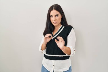 Tecrit edilmiş arka planda duran genç İspanyol kadın tiksinti ifadesi, tiksinti tepkisi yüzünden tiksinti ve korku dolu bir ifade. Eller havada. 