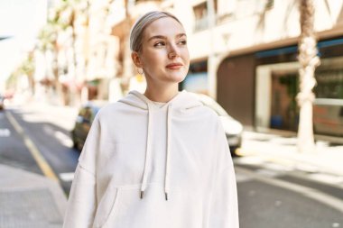 Modern beyaz saç stili ile genç ve güzel bir kadın dışarıda mutlu bir şekilde gülümsüyor.