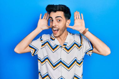 Gündelik giysiler giyen, neşeli gülümseyen, ellerini göstererek bir yuhalama oynayan İspanyol bir genç. Şaşırdım ve çıktım. 