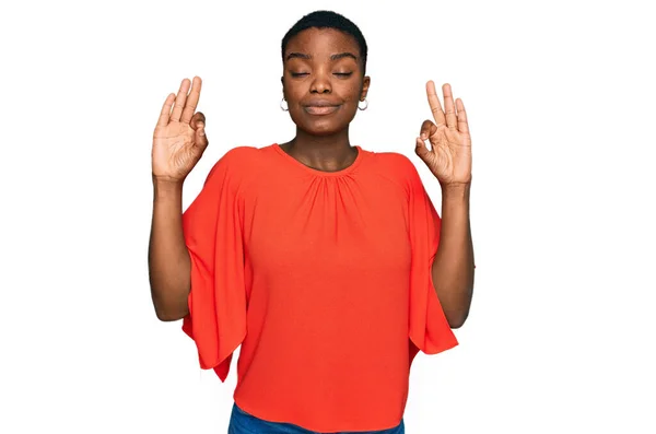 カジュアルな服を着ている若いアフリカ系アメリカ人女性は 指で瞑想ジェスチャーを行う閉じて目でリラックスして笑顔 ヨガのコンセプト — ストック写真