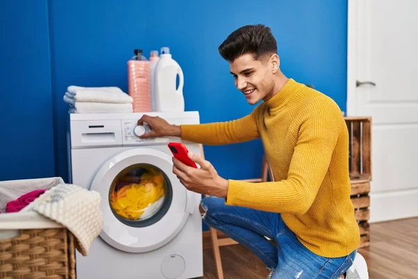 Ung Latinamerikan Man Med Smartphone Tvätta Kläder Vid Tvätt — Stockfoto