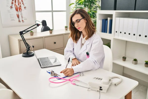 Giovane Donna Che Indossa Medico Uniforme Scrittura Rapporto Medico Presso — Foto Stock