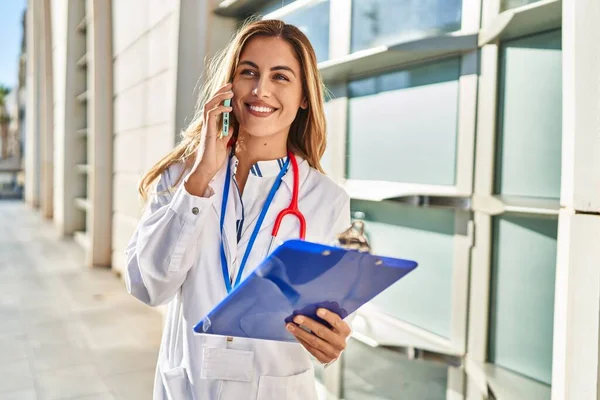 Young Blonde Woman Wearing Doctor Uniform Talking Smartphone Hospital — Stock Photo, Image