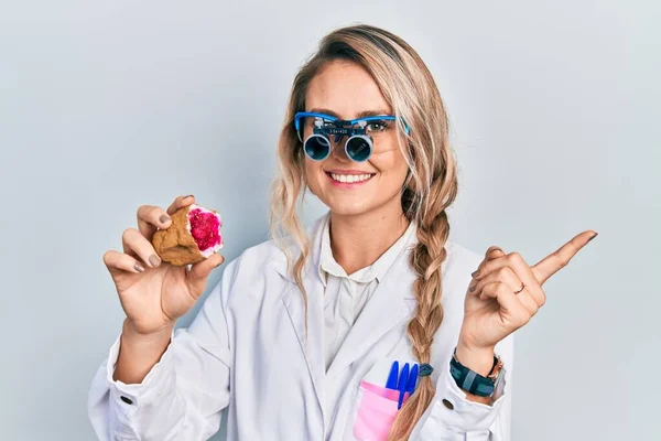 Beautiful Young Blonde Woman Holding Geode Stone Wearing Magnifier Glasses — Stock Photo, Image