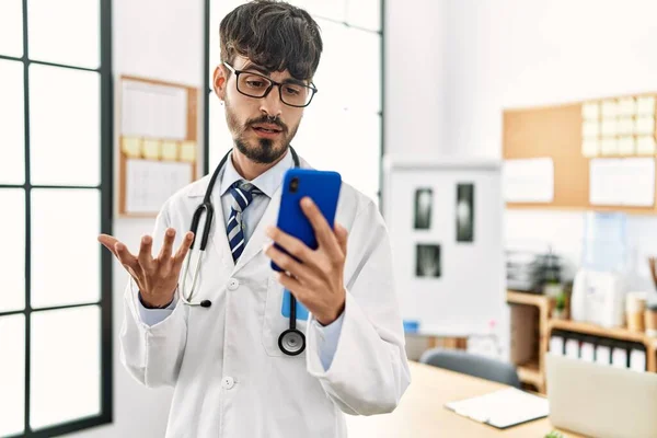 Jovem Hispânico Médico Homem Ter Chamada Vídeo Usando Smartphone Clínica — Fotografia de Stock