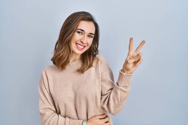 Young Woman Standing Isolated Background Smiling Looking Camera Showing Fingers — стоковое фото