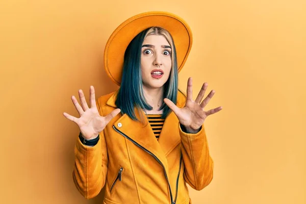 若い現代の少女は 黄色の帽子と革のジャケットを身に着けている恐怖表現を恐れて手でジェスチャーを停止し ショックで叫んでいる パニックの概念 — ストック写真