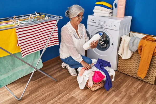 洗濯室で洗濯する中年女性 — ストック写真