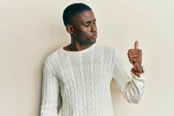 若いアフリカ系アメリカ人の男は誇りを持って見てカジュアルな服を着て 笑顔で親指を横にジェスチャーを行う — ストック写真