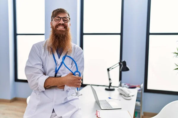 Junger Rothaariger Mann Arztuniform Steht Mit Verschränkten Armen Klinik — Stockfoto