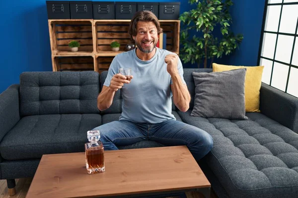 Hombre Guapo Mediana Edad Bebiendo Vaso Whisky Sentado Sofá Gritando —  Fotos de Stock