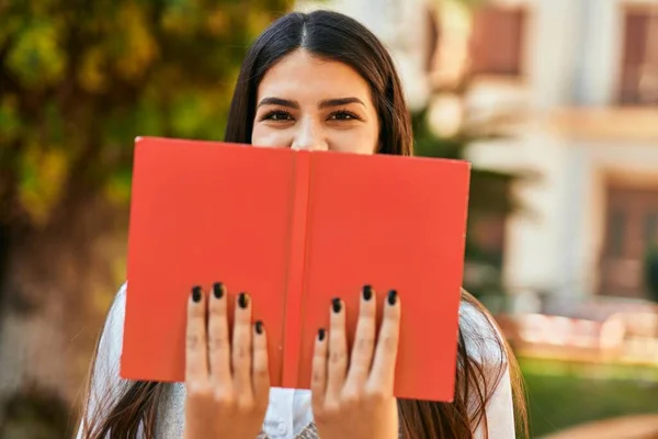 Jovem Hispânica Sorrindo Feliz Rosto Cobertura Com Livro Cidade — Fotografia de Stock