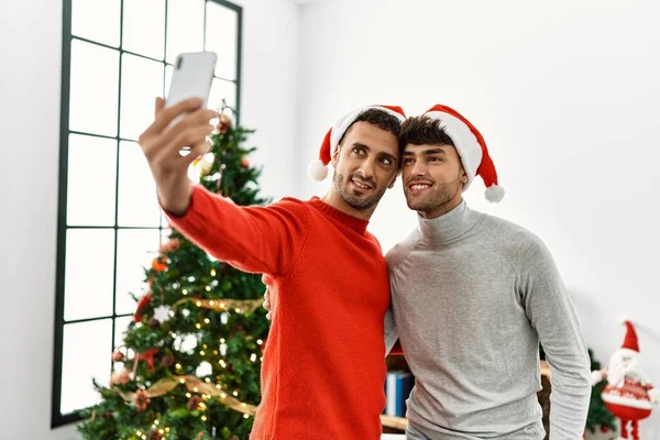 一对惊慌失措的夫妇靠智能手机在家里的圣诞树旁自投罗网 — 图库照片