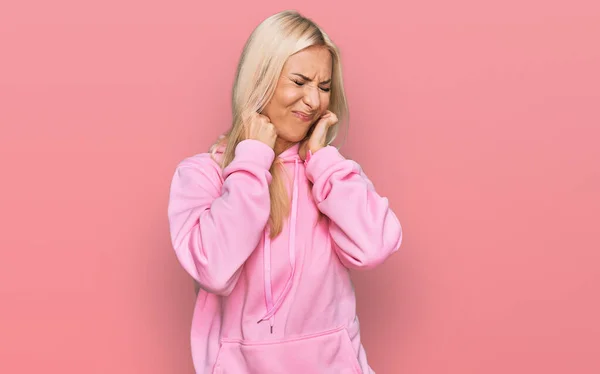 Ung Blond Kvinna Bär Casual Sweatshirt Täcker Öronen Med Fingrar — Stockfoto