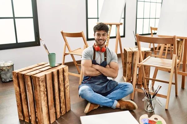 Young Hispanic Man Sitting Art Studio Happy Face Smiling Crossed — Stok fotoğraf