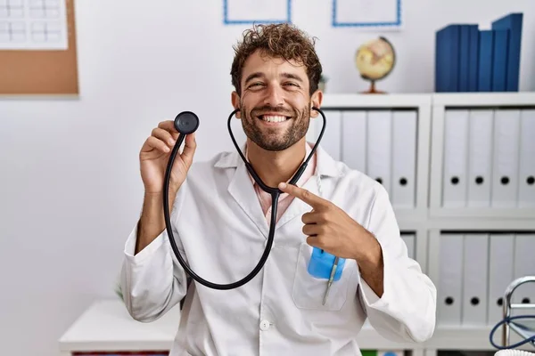 Ung Latinamerikansk Läkare Man Klädd Läkare Uniform Hålla Stetoskop Kliniken — Stockfoto