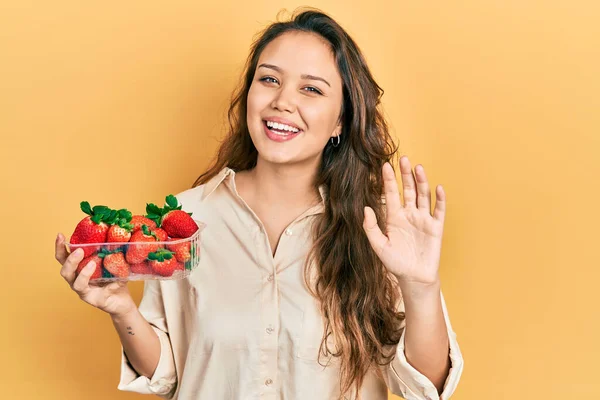 Joven Chica Hispana Sosteniendo Fresas Renunciando Decir Hola Feliz Sonriente —  Fotos de Stock