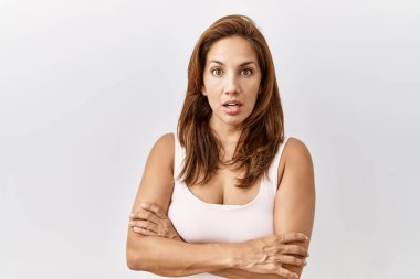 Orta yaşlı İspanyol kadın tecrit edilmiş arka planda duruyor. Şaşırmış ve korkmuş bir ifade, korku ve heyecanlı bir yüz ifadesi var.. 