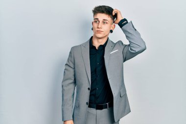 Kulakları genişlemiş, iş ceketi giymiş, kafası karışmış ve soru soran beyaz bir çocuk. Şüpheyle kararsız, kafa kafaya düşünerek. Düşünceli kavram. 