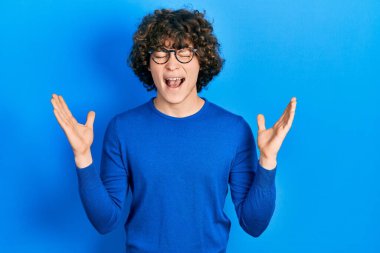 Yakışıklı genç adam gündelik giysiler ve gözlük takarak başarının çılgınlığını kutluyor kolları havada ve gözleri kapalı heyecanla bağırıyor. Kazanan konsept 