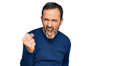 Orta yaşlı İspanyol bir adam, günlük kıyafetler giyiyor kızgın ve kızgın. Öfkeyle bağırırken yumruğunu kaldırıyor. öfke ve agresif konsept. 