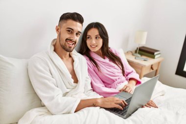 Genç İspanyol çift evde dizüstü bilgisayar kullanıyor..