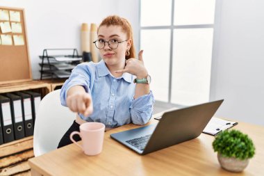 Ofiste çalışan genç kızıl saçlı bir kadın bilgisayarla gülümsüyor telefonla konuşuyor ve seni işaret ediyor. Ara beni.. 