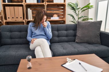 Muayenehanedeki genç esmer kadın kendini kötü hissediyor ve soğuk algınlığı veya bronşitin belirtisi olarak öksürüyor. sağlık hizmeti kavramı. 