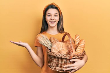 Genç esmer kız elinde hasır sepetle zaferi kutlayan bir ekmek, mutlu bir gülümseme ve kaldırılmış ellerle kazanan bir yüz ifadesi tutuyor. 