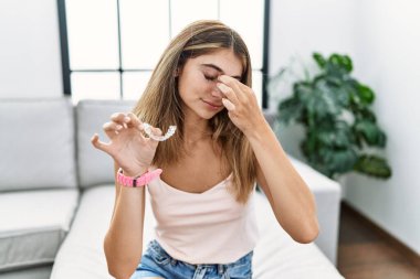 Görünmez hizada duran sarışın kadın ortodontik yorgun burnu ve gözleri ovuşturuyor yorgunluk ve baş ağrısı hissediyor. Stres ve hüsran kavramı. 