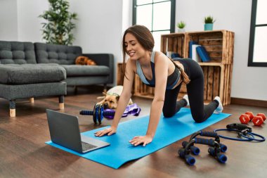 Evde esneme kursu aldığından emin bir şekilde gülümseyen genç İspanyol kadın.