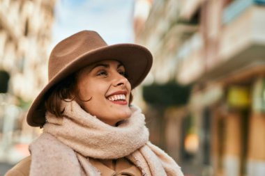 Şık giyinen genç İspanyol kadın şehirde dikiliyor..