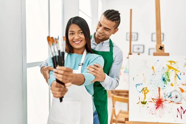 Young Latin Painter Couple Smiling Happy Holding Paintbrushes Art Studio — Φωτογραφία Αρχείου