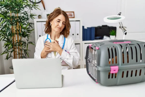 Middle Age Veterinarian Woman Working Pet Clinic Smiling Hands Chest — Stockfoto