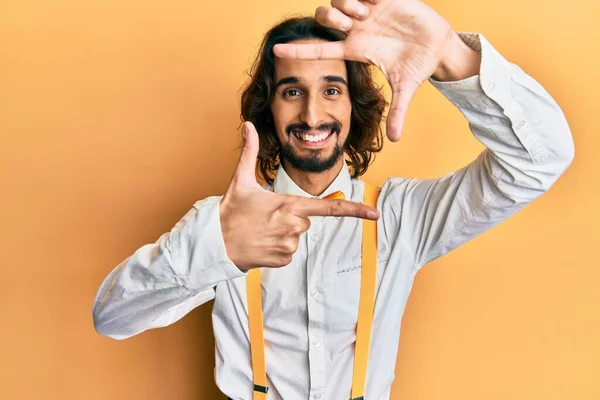 ヒップスターでエレガントな表情をした若いヒスパニック系の男が幸せな顔で手や指でフレームを作り笑顔 創造性と写真の概念 — ストック写真