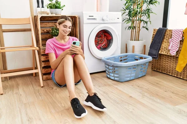 Ung Kaukasisk Kvinna Med Smartphone Väntar Tvättmaskin Tvättstugan — Stockfoto